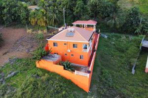 ein orangefarbenes Haus auf einem grünen Feld in der Unterkunft Fraser's Suites in Kingstown