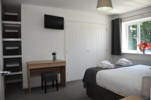 a hotel room with a bed and a desk and a window at Maen Llwyd in Llanyre