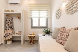 a living room with a couch and a window at Porto Dema Luxury Suites in Schinoussa +180 photos