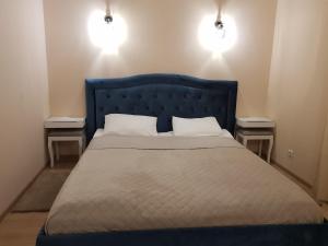 a bedroom with a blue bed with two night stands at Holiday Apartments with loggia in Druskininkai in Druskininkai