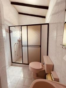 een badkamer met een toilet en een douche bij finca de descanso y recreacion, fogata,piscina. in Cali