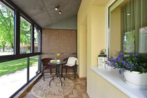 a screened in porch with a table and flowers at Holiday Apartments with loggia in Druskininkai in Druskininkai