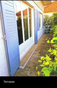 eine blaue Tür eines Hauses mit einer Veranda in der Unterkunft Maison proche gare RER-Aéroport -Paris-Disney-Asterix-Parc des Expositions de Villepinte et Le Bourget in Vaujours