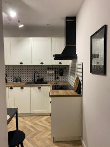 a kitchen with white cabinets and a stove top oven at Apartament Frezja in Gryfów Śląski +10 photos