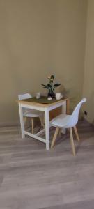 einen Tisch und zwei weiße Stühle sowie einen Tisch und einen Tisch mit Stühlen in der Unterkunft Monastir28 in Turin