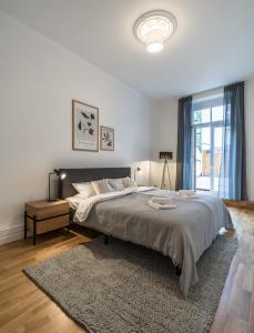 a white bedroom with a large bed and a rug at Hochwertige Altbauwohnung im modernen Stil in Wiesbaden - Küche - Terrasse - WLAN - Zentral in Wiesbaden
