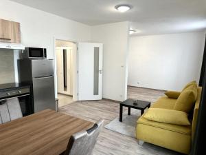 a living room with a yellow couch and a kitchen at Sky apartments 508 in Pilsen