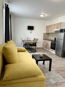 a living room with a yellow couch and a table at Sky apartments 508 in Pilsen