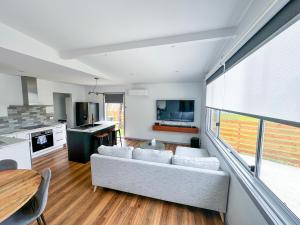 a living room with a couch and a table at Luxury Holiday Unit 8min walk to Town Center with Boat Parking in Mallacoota