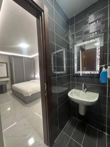 a bathroom with a sink and a mirror and a bed at cozy rooftop near al services 23 in Rujm ash Sharāʼirah +20 photos