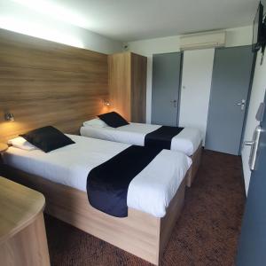 Tempat tidur dalam kamar di Enzo Hotels Loudeac By Kyriad Direct