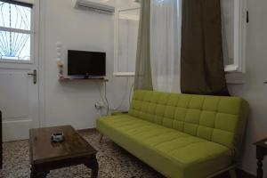 salon z zieloną kanapą i stołem w obiekcie Sigma Acropolis Upstairs w Atenach