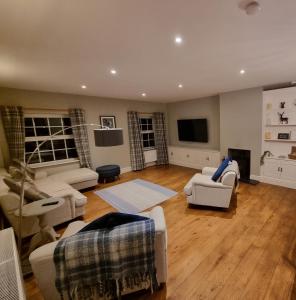 a living room with couches and a flat screen tv at Dove View Hartington: luxury 3 bed cottage in Hartington