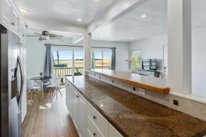 a kitchen with white cabinets and a counter top at Beachside Oasis in Seal Beach