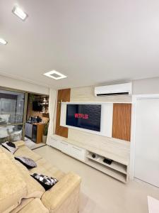 uma sala de estar com dois sofás e uma televisão em Edifício Maximus em Vila Velha
