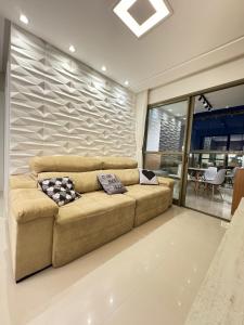 uma sala de estar com um sofá castanho num quarto em Edifício Maximus em Vila Velha