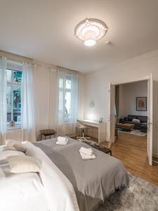 a bedroom with a large bed and a living room at Hochwertige Altbauwohnung im modernen Stil in Wiesbaden - Küche - Terrasse - WLAN - Zentral in Wiesbaden