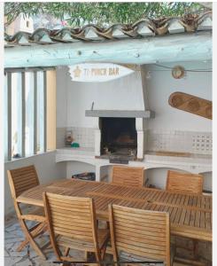 BédarridesにあるMaison de famille au cœur de Bédarridesの木製テーブル(椅子付)、暖炉