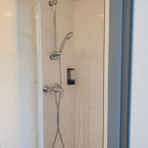 a shower with a shower head in a bathroom at Enzo Hotels Loudeac By Kyriad Direct in Loudéac