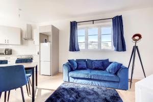 a living room with a blue couch and a kitchen at 2 Bedroom Apartment in Brixton with Wi-Fi in London