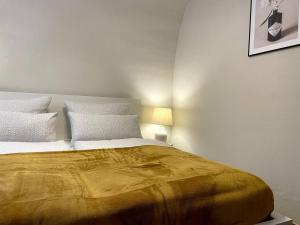a bedroom with a large bed with a yellow blanket at Design-Suite Am Markt in Pirna