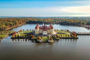 an island with a castle in the middle of a lake at Design-Suite Am Markt in Pirna