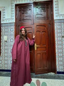 a woman standing in front of a wooden door at Dar Yassine in Rabat