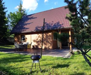 a house with a bbq grill in the yard at Domki na granicy in Jeżowski Dział