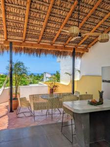 a dining room with a table and chairs and a patio at Penthouse -Sky at Mikasa- Fast wifi, King Bed, AC & Pool in Puerto Escondido