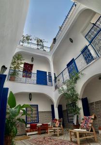 un gran edificio con sillas y techos azules y blancos en Riad Yu Yu, en Marrakech
