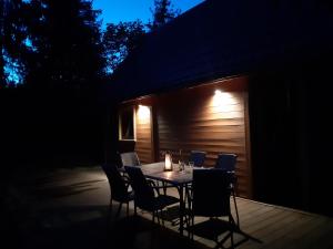 een tafel en stoelen op een patio in de nacht bij Domki na granicy 