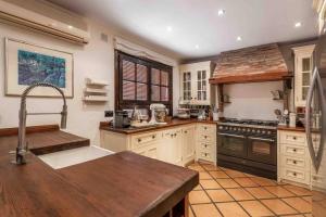 a large kitchen with white cabinets and a sink at Casa del Paraiso in Estepona