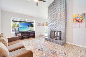 sala de estar con chimenea y TV en Greenway Villa, Newly remodeled, Pool, Putting green and Patio en Phoenix
