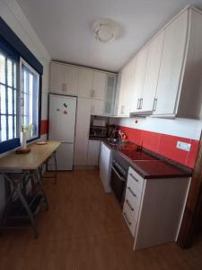 a kitchen with white cabinets and a table in it at Casa La Fabriquilla en Cabo de Gata, Almería, Spain in Almería