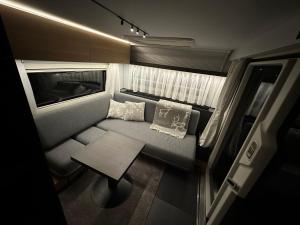 um pequeno quarto com um sofá e uma mesa em Santa`s luxury trailer em Rovaniemi
