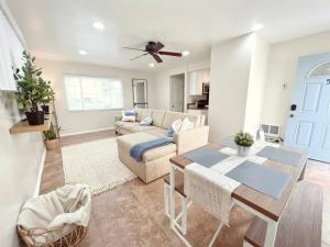 ein Wohnzimmer mit Sofa und Tisch in der Unterkunft Historical Beach Bungalow Steps Away From Sand #5 in Newport Beach