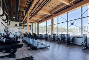 een fitnessruimte met rijen loopbanden en cardio-apparatuur bij Friday Harbour resort apartment in Innisfil