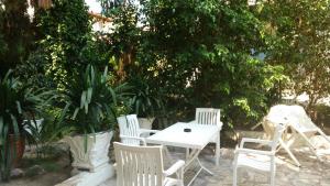 einen weißen Tisch und Stühle vor einem Baum in der Unterkunft Pension Alkistis in Tolo