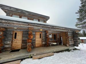 a log cabin with a deck in the snow at Ruka Saaruakuja 3 as 1-4 in Ruka