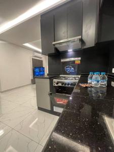 a kitchen with a stove and a counter top at cozy rooftop near al services 24 in Rujm ash Sharāʼirah