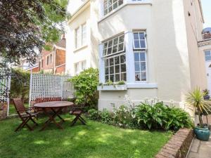 a garden with a table and chairs in front of a house at Holland House in New Brighton