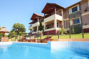 a resort with a swimming pool in front of a building at Mirador Serrano in Merlo