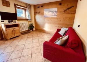 a living room with a red couch and a tv at Chalet Nano in Livigno