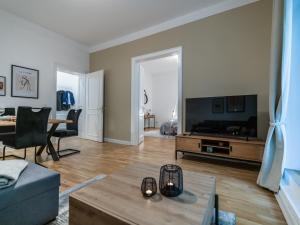 a living room with a flat screen tv and a couch at Hochwertige Altbauwohnung im modernen Stil in Wiesbaden - Küche - Terrasse - WLAN - Zentral in Wiesbaden