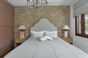 ein Schlafzimmer mit einem großen weißen Bett mit zwei Lampen in der Unterkunft Villa Papis Metsovo in Metsovo