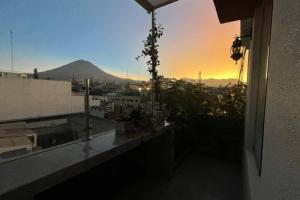 Una vista de una puesta de sol desde el balcón de un edificio. en Apartment with amazing view, en Arequipa