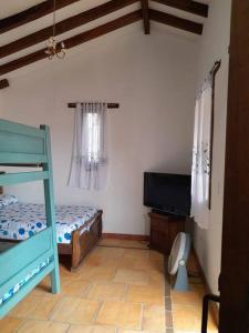 1 dormitorio con litera y TV de pantalla plana en Cabaña Colonial Vista Verde, en Tena