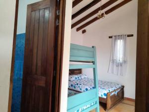 1 dormitorio con litera y puerta en Cabaña Colonial Vista Verde, en Tena