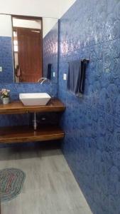 baño con lavabo y pared azul en Cabaña Colonial Vista Verde, en Tena
