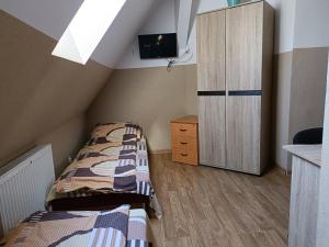 sypialnia z 2 łóżkami i szafką z telewizorem w obiekcie Pokoje na wynajem Gdańsk w Gdańsku
